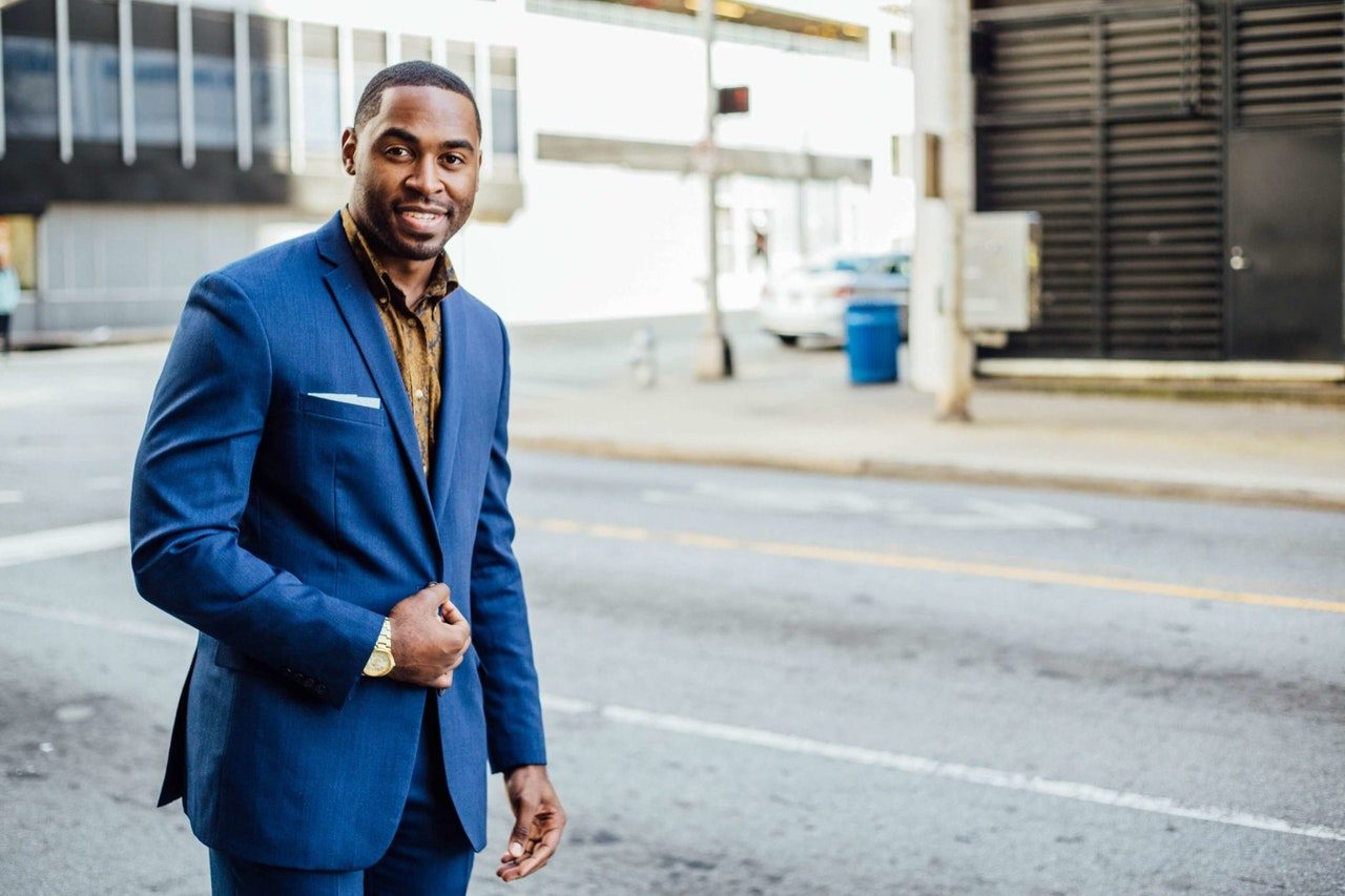 Man in blue suit standing on street.